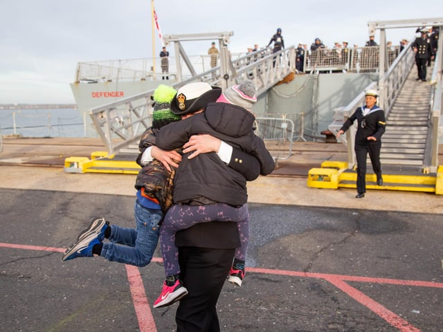 Jenni Smith embraces er children Evelyn 7 and Matthew 5 as she steps of HMS Defender. Picture: Habibur Rahman