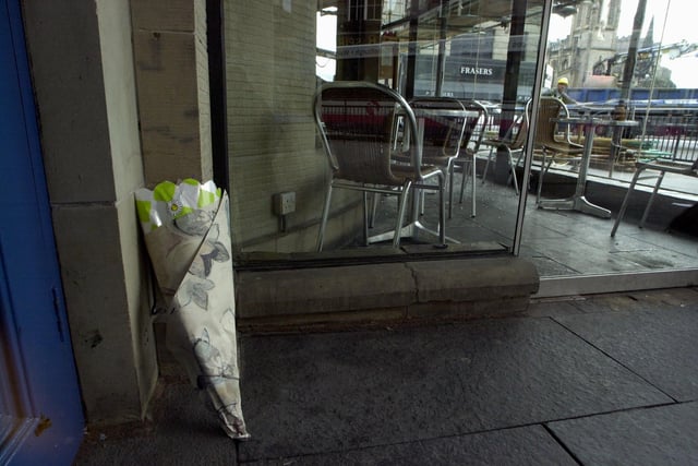 Floral tributes began to appear outside Ryan's Bar in Edinburgh's West End after a young waitress was killed and several others injured when masonry fell from the roof, 30 June 2000.