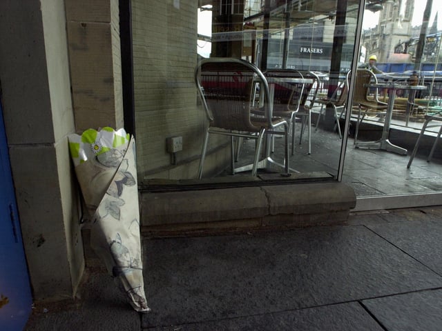 Floral tributes began to appear outside Ryan's Bar in Edinburgh's West End after a young waitress was killed and several others injured when masonry fell from the roof, 30 June 2000.