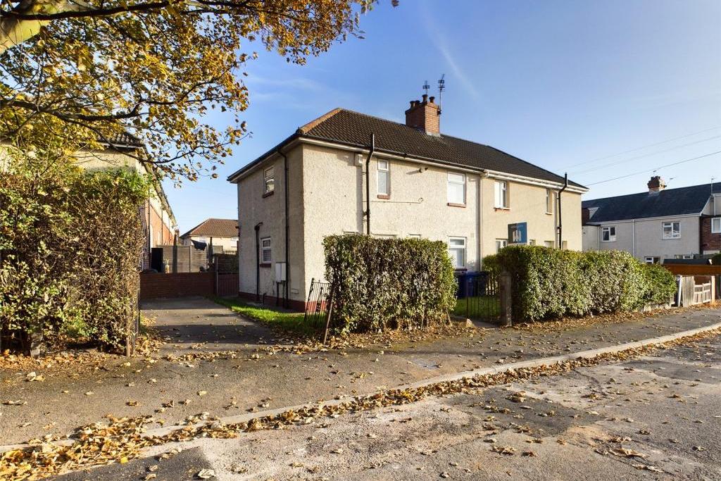 Hedge enclosed with wrought iron access gates, laid to lawn with raised flower bed, paved path and hard standing; access gate opening into the rear garden.