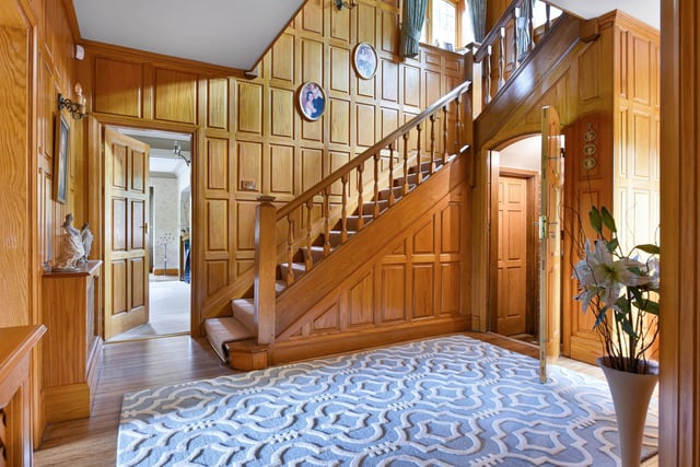The house has an impressive wood paneled entrance hall.
