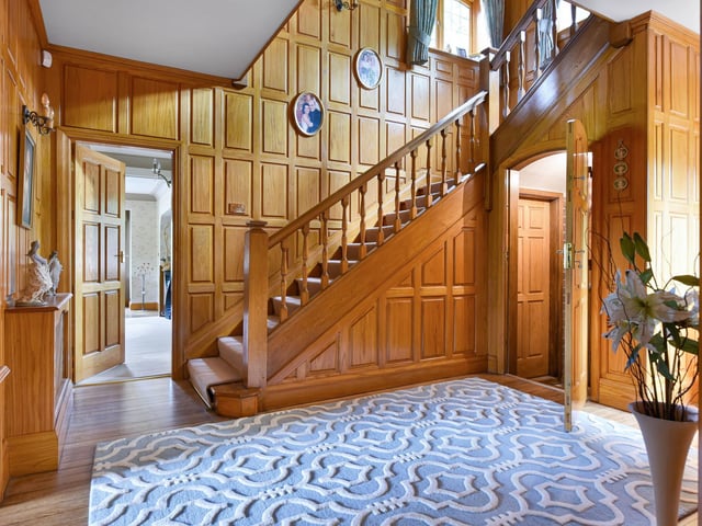 The house has an impressive wood paneled entrance hall.