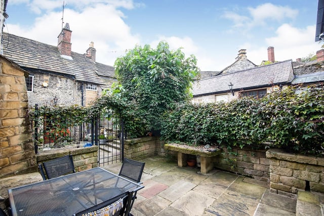The property has a small courtyard to the front with a seating area.