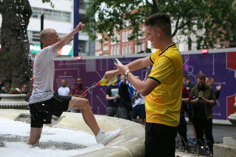 A football fan squirting washing up liquid into a fountain in Leicester Square as crowds descend on London ahead of the Scotland England clash on Friday.