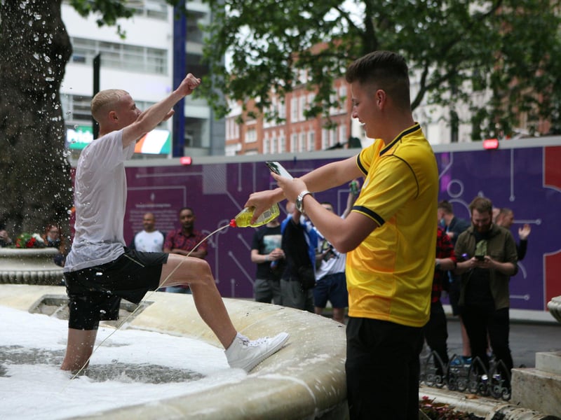 A football fan squirting washing up liquid into a fountain in Leicester Square as crowds descend on London ahead of the Scotland England clash on Friday.