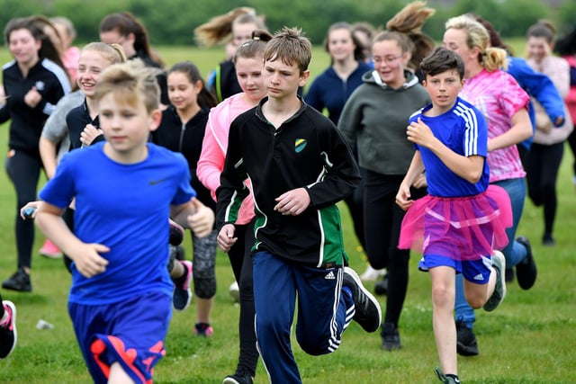 Pupils at Manor Community Academy taking part in their charity 5k run around the sports field. It's a scene from 2018.