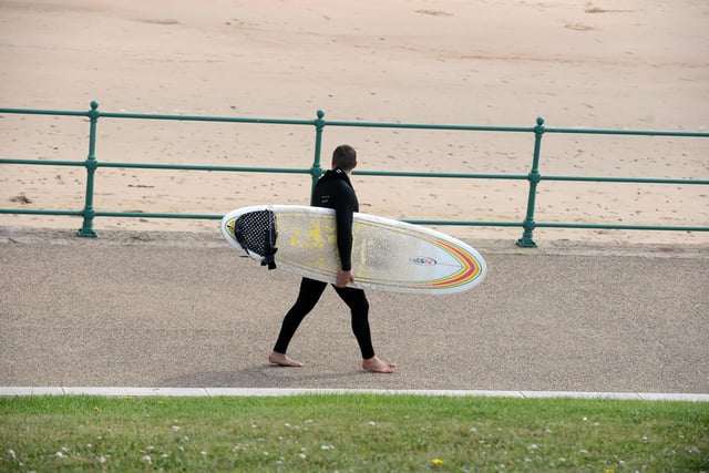 A surfer heads to Seaburn Beach to catch the waves.