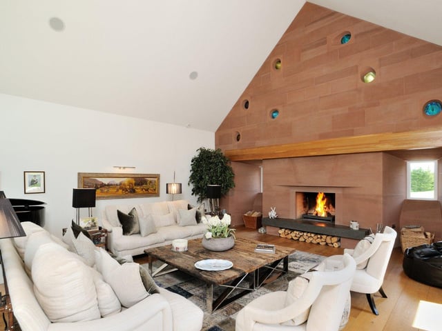 A large open fireplace sits at the centre of the lounge area, with plenty of seating surrounding it to provide a cosy space to relax.