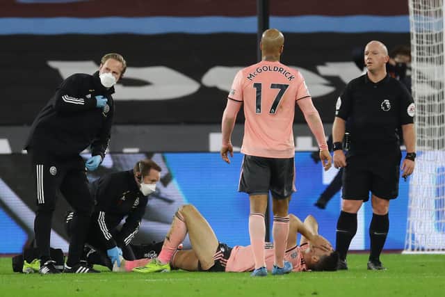 John Egan of Sheffield Utd receives treatment during the Premier League match at the London Stadium, London. Picture date: 15th February 2021. Picture credit should read: David Klein/Sportimage