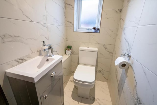 The bathroom has modern tiled walls and flooring, as well as recessed spot lighting.