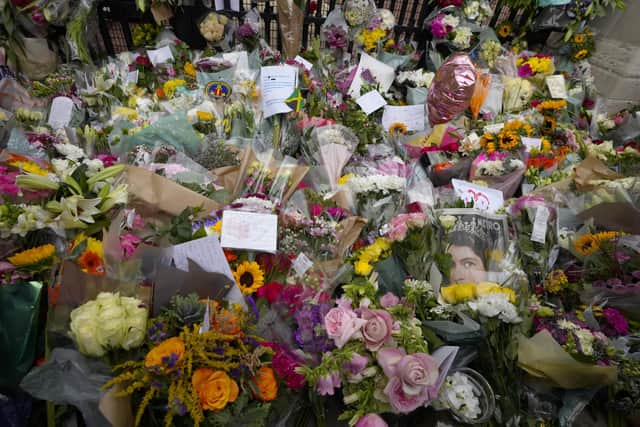 Mourners left flowers at the gates of Buckingham Palace in London, Friday, Sept. 9, 2022. Queen Elizabeth II, Britain's longest-reigning monarch and a rock of stability across much of a turbulent century, died Thursday Sept. 8, 2022, after 70 years on the throne. She was 96. (AP Photo/Kirsty Wigglesworth)