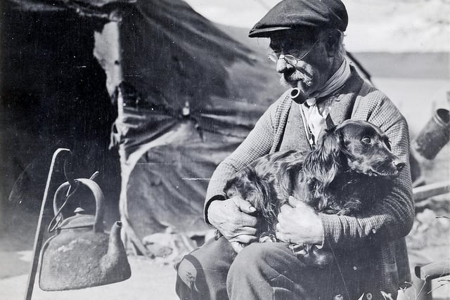 Man and dog wait for the kettle to boil. Through his work Gordon Shennan became a genuine friend of many travelling families, and was welcomed into the sites. He is known to have shared the food he had in times of need.