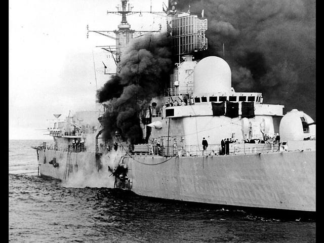 HMS Sheffield burns shortly after being hit by an Argentine Exocet missile, on 4/5/1982, whilst on RADAR picket duties off the coast of the Falkland Islands.  