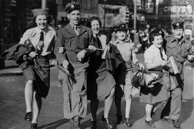 10th August 1945:  WAAFs link arms with soldiers during the VJ Day celebrations in Piccadilly Circus.  (Photo by Keystone/Getty Images)