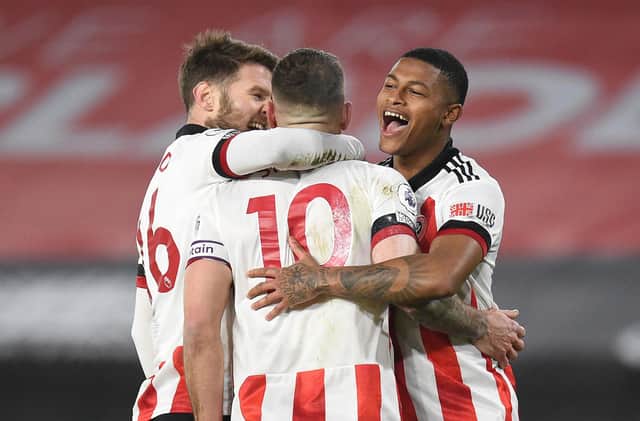 SHEFFIELD, ENGLAND - JANUARY 12: Billy Sharp of Sheffield United celebrates with Oliver Norwood (L) and Rhian Brewster (R) after scoring a penalty for his teams first goal during the Premier League match between Sheffield United and Newcastle United at Bramall Lane on January 12, 2021 in Sheffield, England. Sporting stadiums around England remain under strict restrictions due to the Coronavirus Pandemic as Government social distancing laws prohibit fans inside venues resulting in games being played behind closed doors. (Photo by Oli Scarff - Pool/Getty Images)