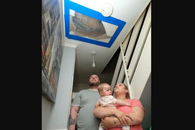 Dad Michael Bickerdyke was hurt when he fell through ceiling in a Sheffield council house after concerns had been raised over water leaks.  Tanya Hearson and Michael Bickerdyke are pictured with baby Elena-Jade, under the hole in the ceiling