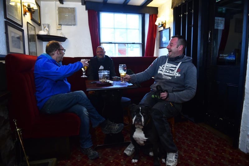 People enjoy a drink at The Swan Inn pub. (Photo by Nathan Stirk/Getty Images)