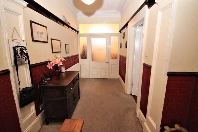 The wide entrance hall has staircase to the upper floors and a closed off staircase leading down to the basement.