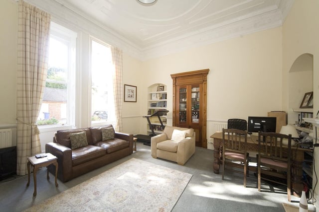 The spacious snug/family room also features a stunning fireplace, sash windows with original shutters providing a view to the front of the property.