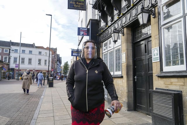 A masked shopper strolls past the closed Olde Castle pub in Doncaster Market Place.