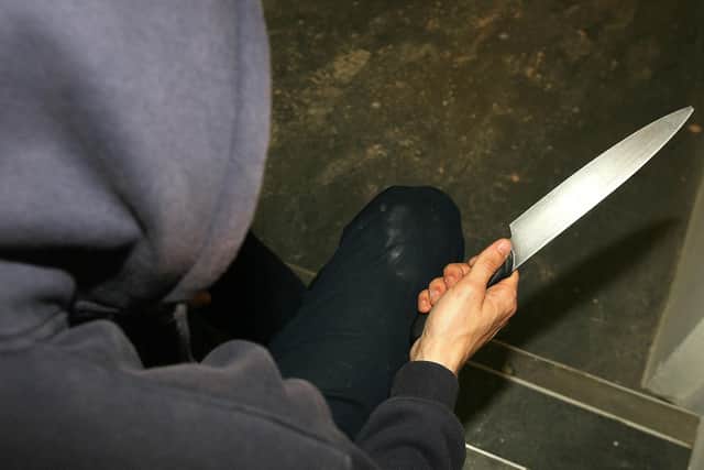 PICTURE POSED BY MODEL File photo dated 25/4/09 of a man in a hoodie holding a knife. The number of young offenders cautioned or sentenced after being caught with knives has hit the highest level for nearly eight years.