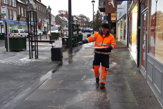 A council worker puts salt down on footpaths on Marygate.
