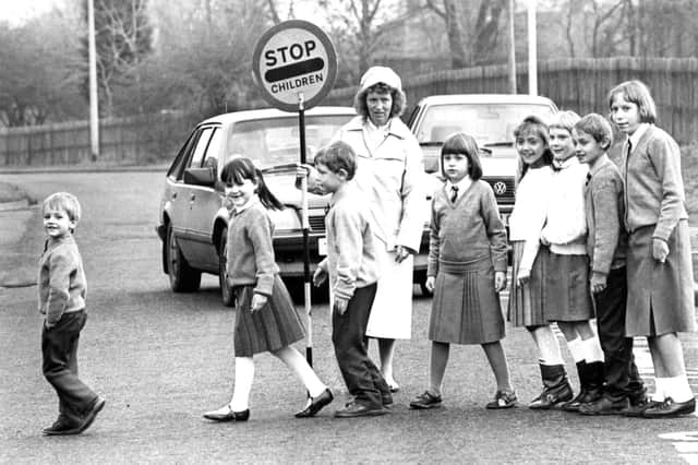 Anne Landles safely sees these children across the road at Bede Burn County Junior Mixed and Infants School, Jarrow in 1988. Does this bring back memories of getting to school?