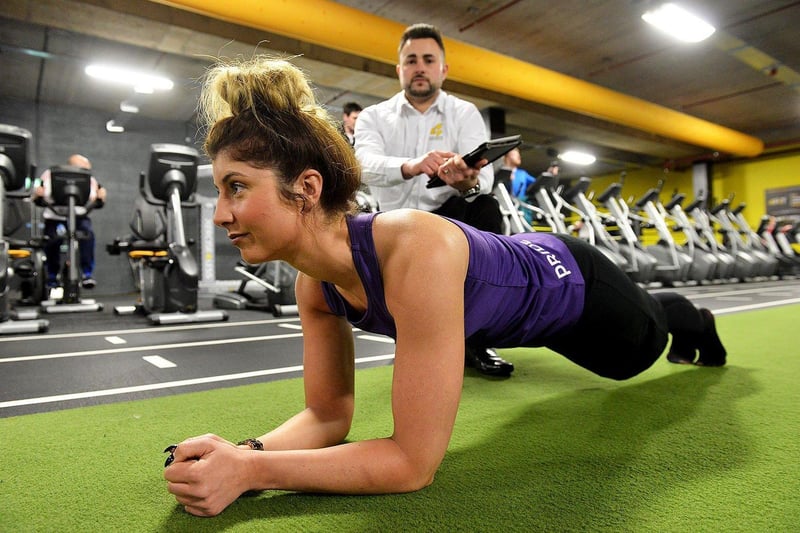 Karl Brown (sales and marketing manager) watches Chelsea McKie planking as she trains for a charity event at Xercise4Less in 2017.