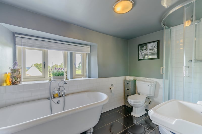 Here's one of the farmhouse's two bathrooms - it has a modern suite with full tiling to the floor, partial tiling to the walls and windows facing the front of the property.