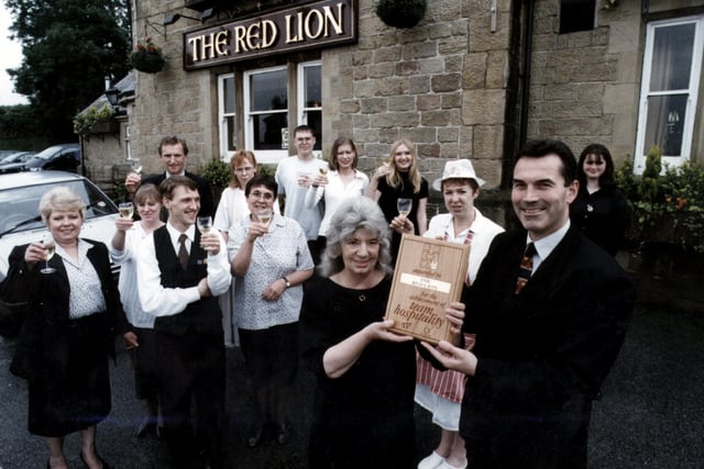 Whitbread Sherwood Inns operations manager, Neil Barbour (front right), is presenting the Team Hospitality award to bar person Dora Singleton with other members of staff from The Red Lion on Penistone Road North, Grenoside, July 1997