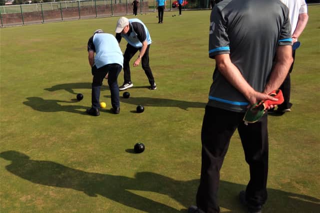 Bowling Action: Measure taking place to determine which bowl is closer to the jack. Picture: Trevor Curtis