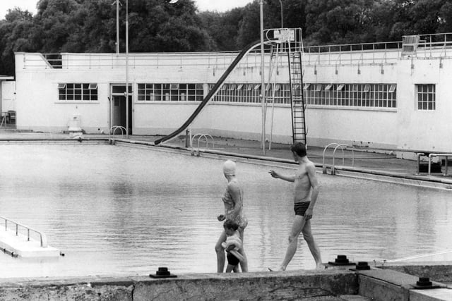 Swimmers walk past the pool in August 1972