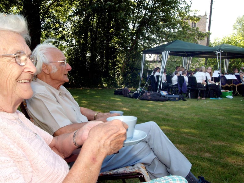 Peggy Chapman and Eric Hawkes enjoy a cream tea whilst listening to the Shirebrook Unison Band at Warsop Church Garden Party