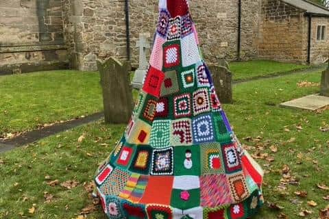 One of the four handmade knitted Christmas trees made by the Kiveton knitting and Crochet group in Sheffield placed outside the Church.