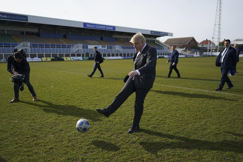 Britain's Prime Minister Boris Johnson kicks a soccer ball during a visit to the Hartlepool United Football Club, in Hartlepool, England ahead of the May 6 by-election, Friday April 23, 2021. (Ian Forsyth/Pool via AP)