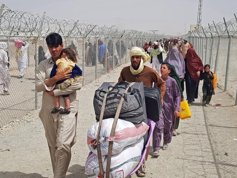 Stranded Afghan nationals arrive to return back to Afghanistan at the Pakistan-Afghanistan border crossing point in Chaman on August 16, 2021 as the Taliban were in control of Afghanistan after President Ashraf Ghani fled the country and conceded the insurgents had won the 20-year war.