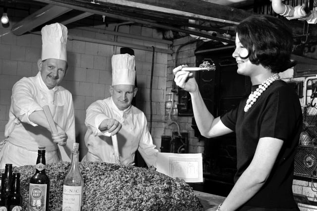 A 340lb Christmas pudding being mixed by pastry chef Danny Morton with second chef William Milne, and tasted by receptionist Olivia Renylel, at the Caledonian Hotel in 1965.