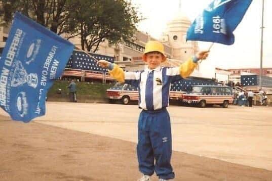 An eight-year-old Dave Dowling waves Wednesday colours in front of the famous Wembley towers.