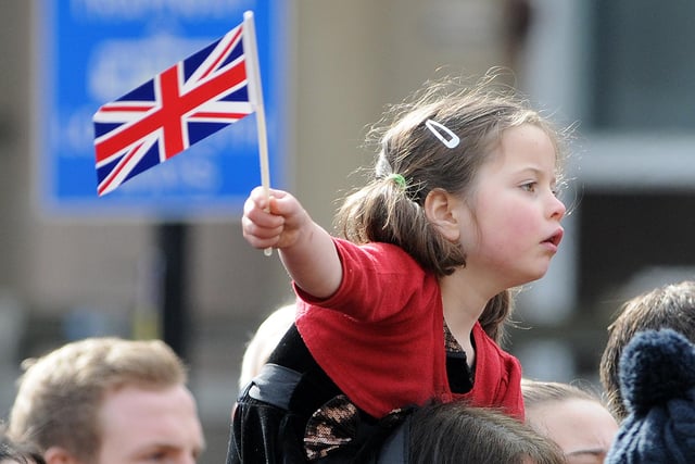 One youngster waves a flag as she wait for the Queen outside Sheffield Cathedral for Maundy Thursday. Picture: Andrew Roe