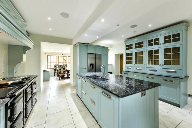The kitchen has a large central island, four oven AGA and painted timber units.
