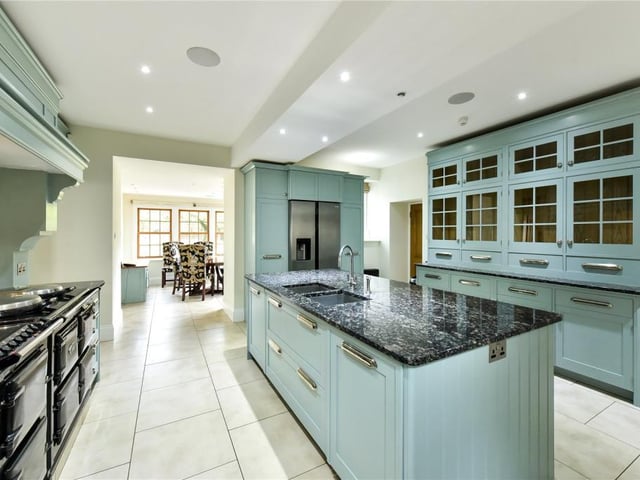 The kitchen has a large central island, four oven AGA and painted timber units.