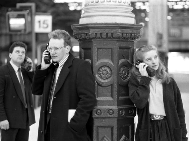 Business people - 'yuppies' - using mobile phones at Waverley station in Edinburgh, January 1990.