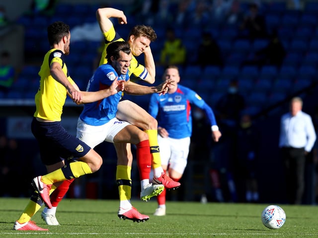 John Marquis is challenged by Rob Dickie of Oxford United