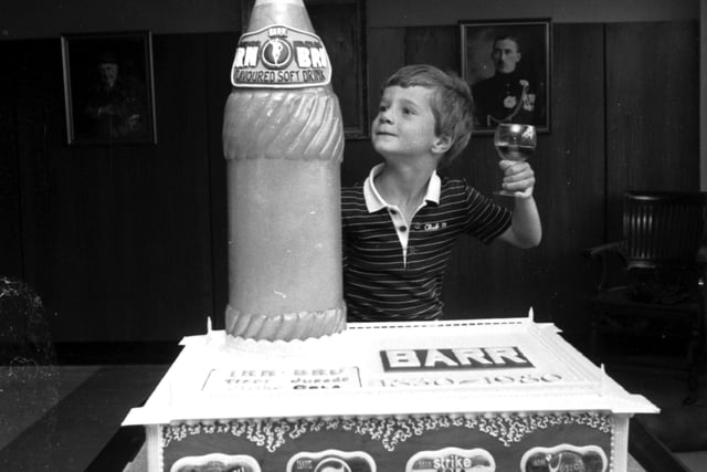 Graham Barr raises a glass beside a cake to celebrate the 150th anniversary of the Irn-Bru company in Glasgow in August 1980.