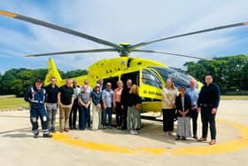 B. Braun staff stood in front of a Yorkshire Air Ambulance helicopter.