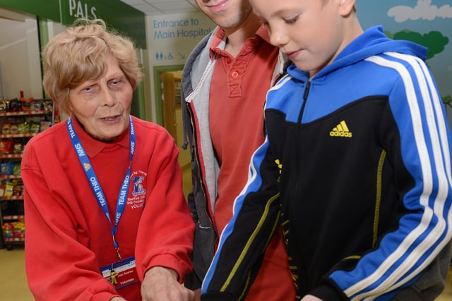 Joan Searles, a long-time volunteer at Sheffield Children's Hospital, pictured in 2013 giving directions to Lewis Marshall and his dad Mike