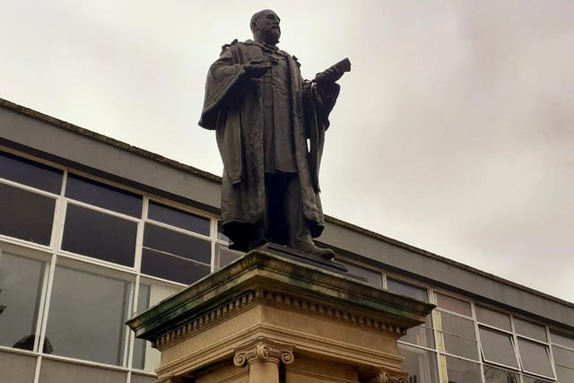 Whose statue stands opposite Jarrow Town Hall?