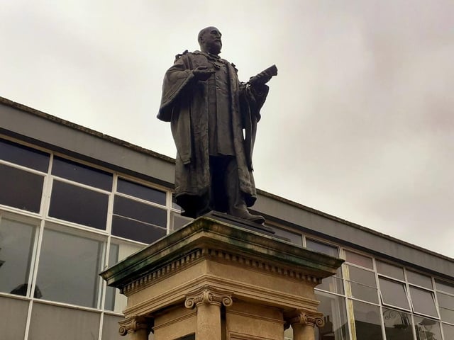 Whose statue stands opposite Jarrow Town Hall?