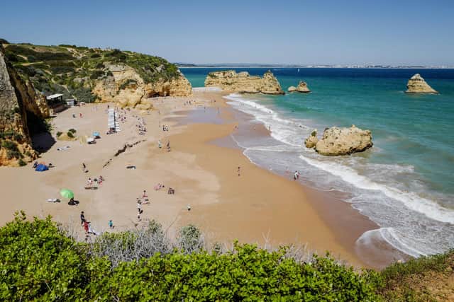 People enjoy the warm weather at the Dona Ana beach in Lagos on April 18, 2018 in the southern Portugal region of Algarve. (Photo by Ludovic MARIN / AFP)        (Photo credit should read LUDOVIC MARIN/AFP via Getty Images)