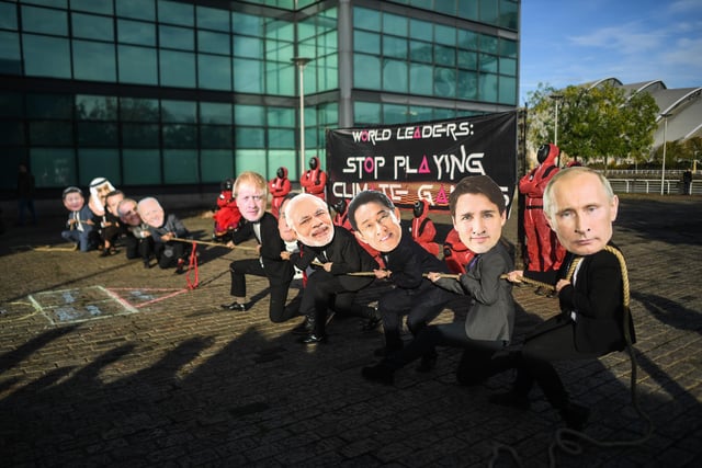 Activists wearing world leader costumes play 'Squid Game' games.